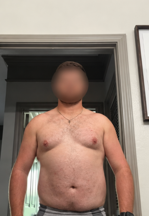 A shirtless man stands facing forward in a doorway for a fitness progress update.