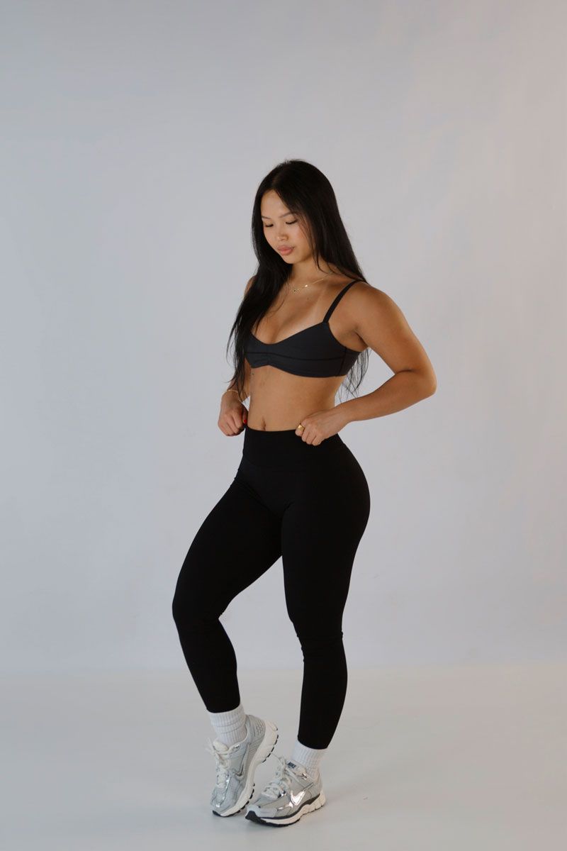 Coach at the gym with her back facing the camera.