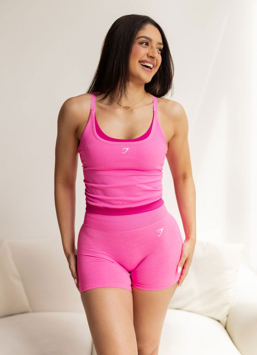 The coach is smiling while wearing pink clothes.