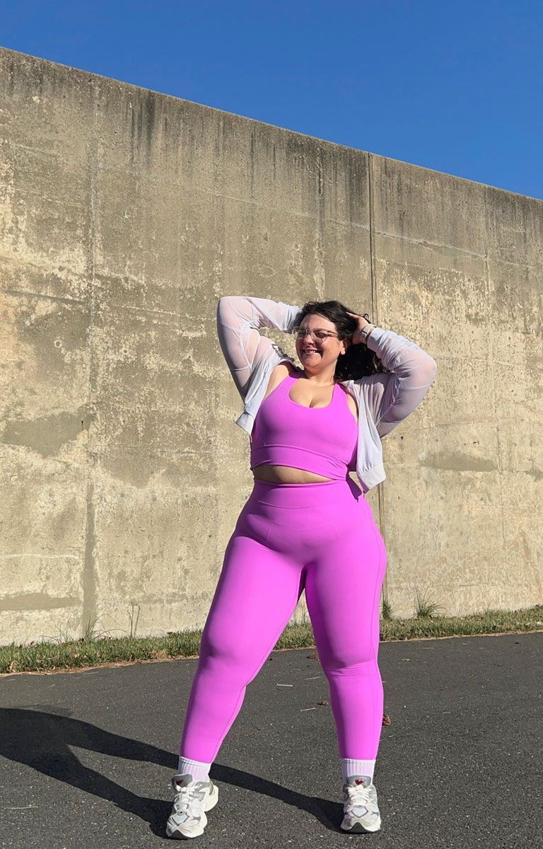 The coach is posing while wearing a purple clothing.