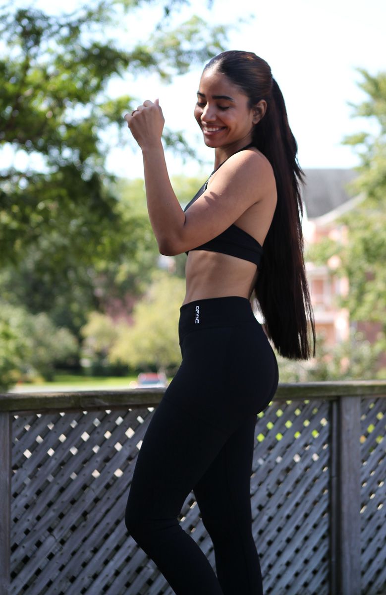 Coach is posing in a black workout outfit.