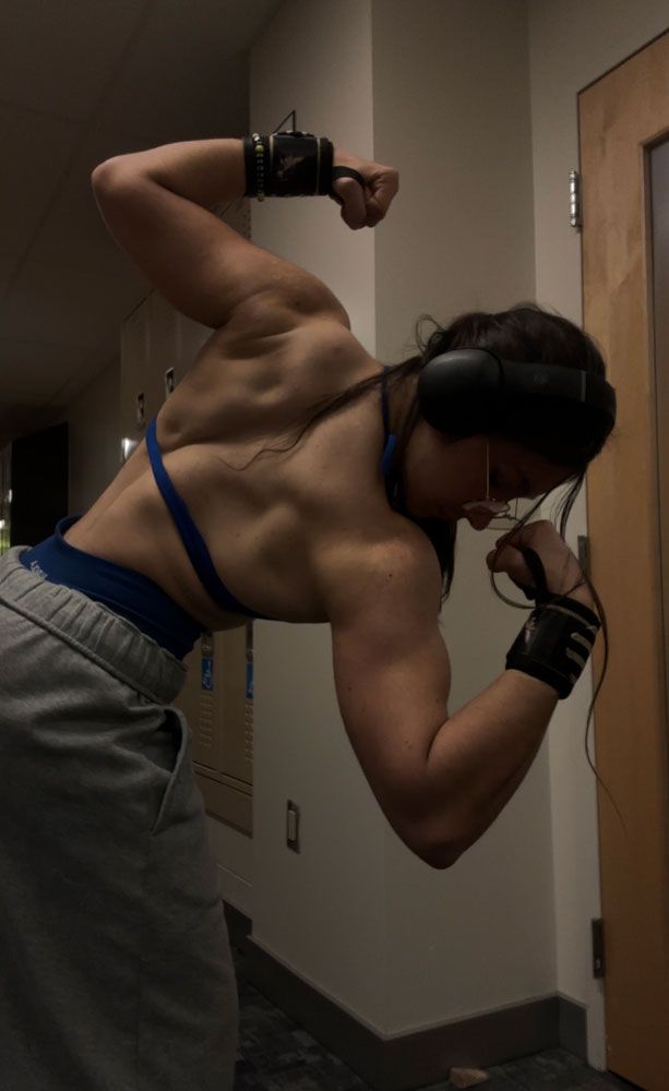 The coach is showing her back muscle.