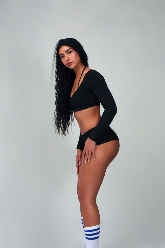 Claire standing in a black crop top and shorts