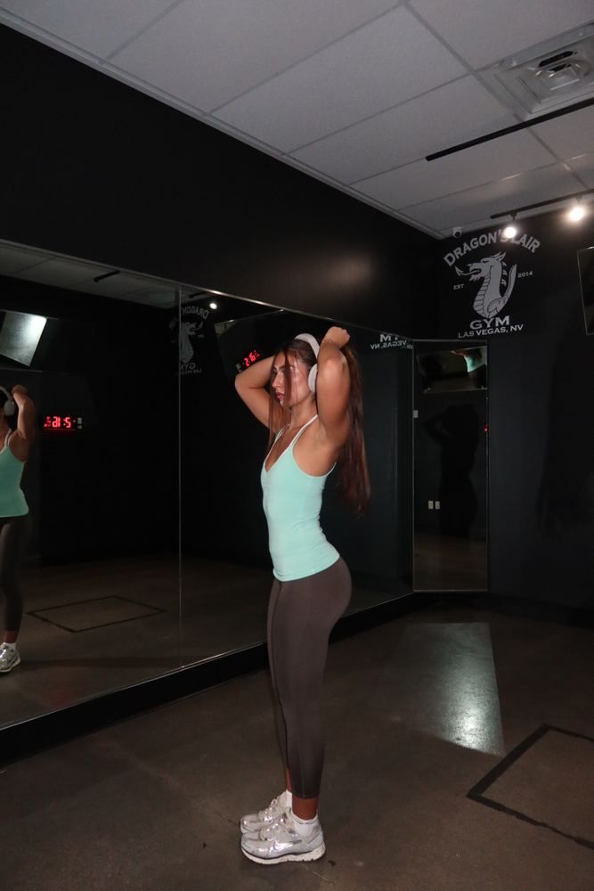 Claire in profile tying her hair back in the gym