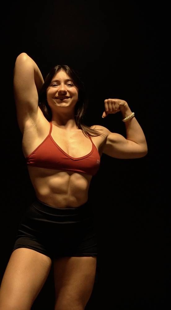 Kacey flexing and laughing under studio lighting